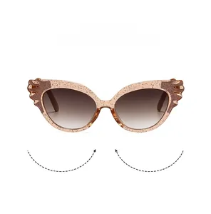 Detail of pink glitter cat-eye sunglasses with gradient lenses and wing carvings