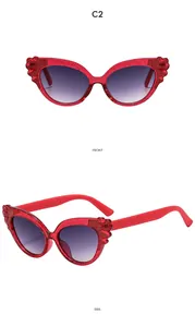 Front and side views of red cat-eye kids' sunglasses with wing detail and glitter