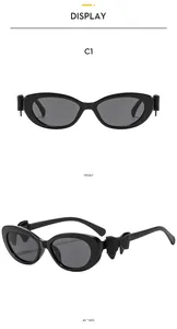 Détail des lunettes de soleil ovales noires avec décoration de nœud sur les branches