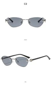 Detail of rimless cat-eye sunglasses with silver cross accents and black temples