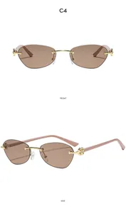 Detail view showing golden floral hinge and pink arms of rimless cat-eye sunglasses