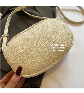 Detailed macro view of the cream white litchi textured leather on this stylish pillow bag