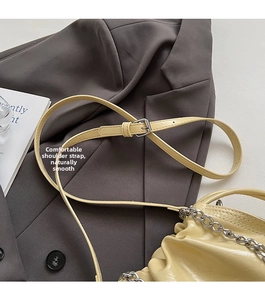 Detailansicht der beigen Falten-Ledertasche mit Silberkette und verstellbarem Gurtband