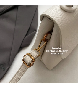 Détails des ferrures dorées et du cuir grainé de ce sac à main couleur blanc ivoire