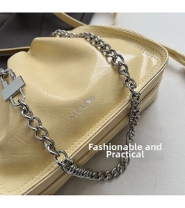 Makroaufnahme von creme-faltigem Leder und silberner Kette mit eingeprägtem CLEAR K Logo
