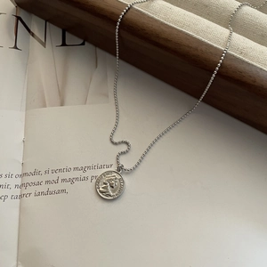 Macro detail of S925 silver bead chain and vintage queen portrait coin pendant