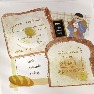 Detailed view of toast-shaped memo pads with butter and fried egg creative designs