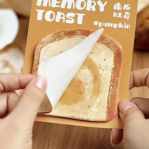 Close-up of toasted bread shaped sticky notes being peeled from the memory toast pad
