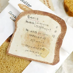 Macro detail of toast-shaped sticky notes with handwriting on baking themed background
