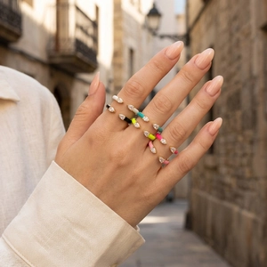 Close-up of colorful enamel open rings with pear-cut cubic zirconia on model's hand