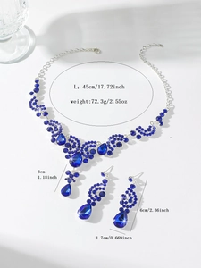 Detailed view of bridal rhinestone necklace and earring set with deep blue crystals
