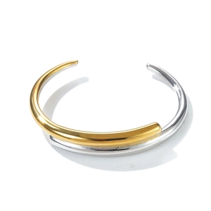Close-up of dual-tone gold and silver layered open bangle with a polished finish