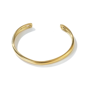 Detail shot of the polished gold cuff bracelet with thickened rounded ends on white background