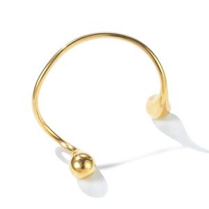 Detailed view of a gold open bangle featuring minimalist dual spherical end ornaments