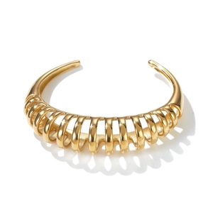 Detailed view of golden open cuff bracelet with hollow spiral texture and polished finish