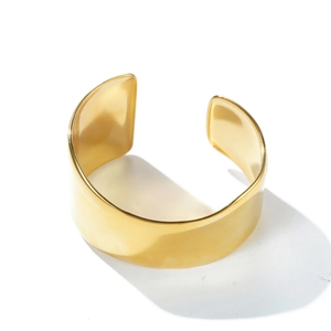 Detailed view of wide open gold cuff bracelet with high polished mirror finish texture