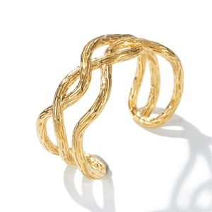 Macro view of gold-plated woven cuff bracelet showing triple-line texture and engraving