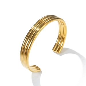 Detailed side view of a minimalist triple-band open cuff gold bracelet in polished steel