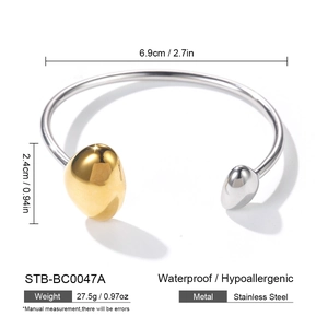 Detail view of two-tone stainless steel open cuff bangle with gold and silver bead ends