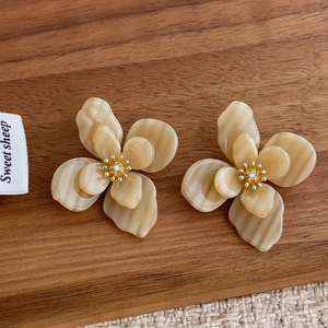 Gros plan sur des boucles d'oreilles fleurs en acrylique à double couche et cristaux