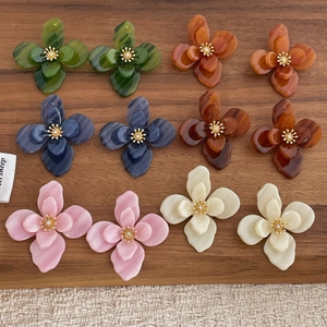 Détail macro de boucles d'oreilles fleurs en acrylique, six couleurs, texture marbrée