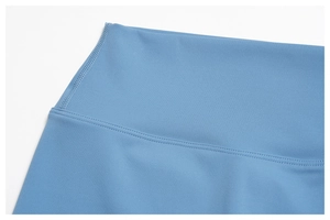 Macro detail of high-waisted seamless waistband with flatlock stitching on blue yoga shorts