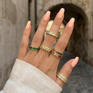 Close-up of elegant 18K gold plated zircon rings on hand with a rustic stone background