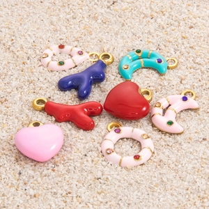 Detail of assorted moon and heart charms with colorful enamel and inset rhinestones