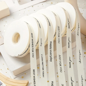 Detail of cream white decorative ribbons with printed black artistic English greetings