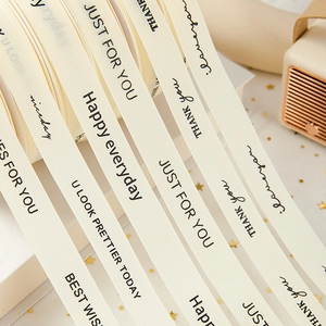 Creamy white grosgrain ribbon with black text for flower bouquet and gift box packaging