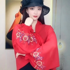 Detail of red chiffon shawl with colorful floral embroidery on lantern sleeves