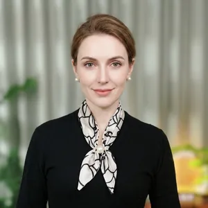Detail of printed chiffon scarf with pearl buckle and matching earrings on woman
