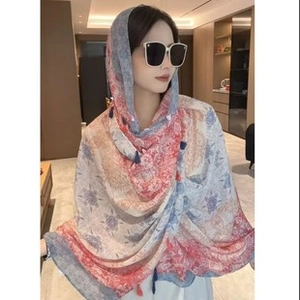 Detail of floral chiffon sun protection shawl with blue tassels and paisley print