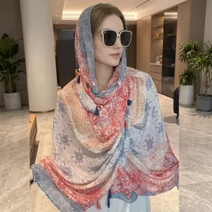 Detail of floral chiffon sun protection shawl with blue tassels and paisley print
