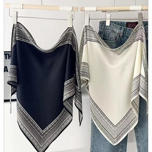 Detail of black and cream silk scarves with ethnic geometric patterns on the edges