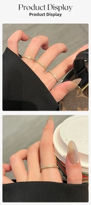 Detail of slim gold titanium ring with micro-paved zircons worn on hand with coffee cup