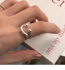 Close-up of minimalist S925 sterling silver double-layered open ring on a book