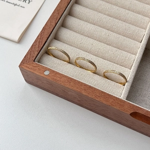 Three minimalist 18K gold-plated titanium rings set with zircon in a wood jewelry box