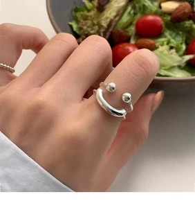 Detail of S925 sterling silver double-layered smiley face ring worn on finger