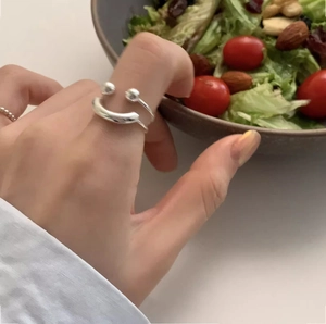 Close-up of minimalist S925 sterling silver smiling face open ring on a model's finger
