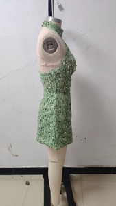 Side view of a sequined halter neck mini dress in emerald green on a mannequin