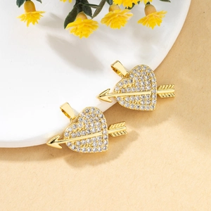 Macro shot of gold-plated heart and arrow pendants with micro-paved cubic zirconia