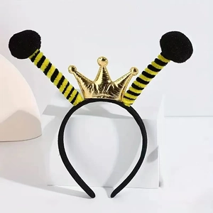 Detail of bee headband with yellow striped feelers, black pom-poms and a small gold crown