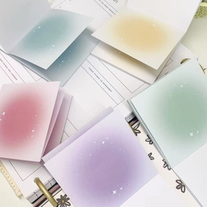 Pastel gradient square memo pads with white star patterns on open notebook page