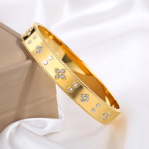 Titanium steel clover bangle with crystals and gold finish on champagne silk