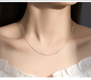 Detailed view of a delicate S925 sterling silver chain worn on a model neck