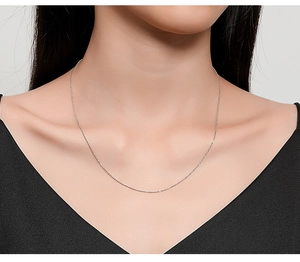 Close-up of a minimalist S925 sterling silver Chopin chain worn on a model's neck