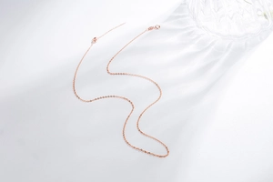 Detail of rose gold thin S925 sterling silver chain with polished metallic finish