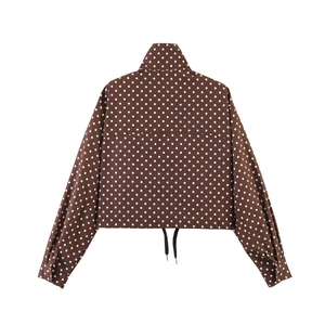 Detail der dunkelbraunen Polka-Dot-Jacke mit Stehkragen und Kordelzug am Saum für Damen