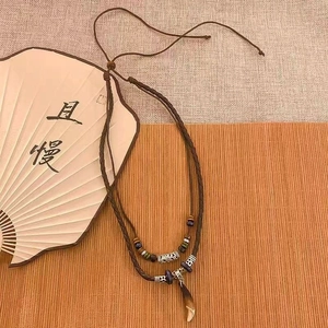 Detail of double-layer beaded necklace with vintage butterfly pendant and ethnic style beads